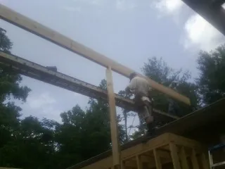 Carpenter setting a ridge beam over a new addition frame — Ice Dam Removal by Roofing Brothers in Anahuac