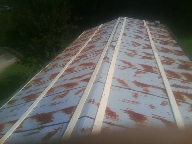 Rusted metal roof panels with new wood purlins before replacement — Storm Damage Roof Repair in Anahuac by Roofing Brothers