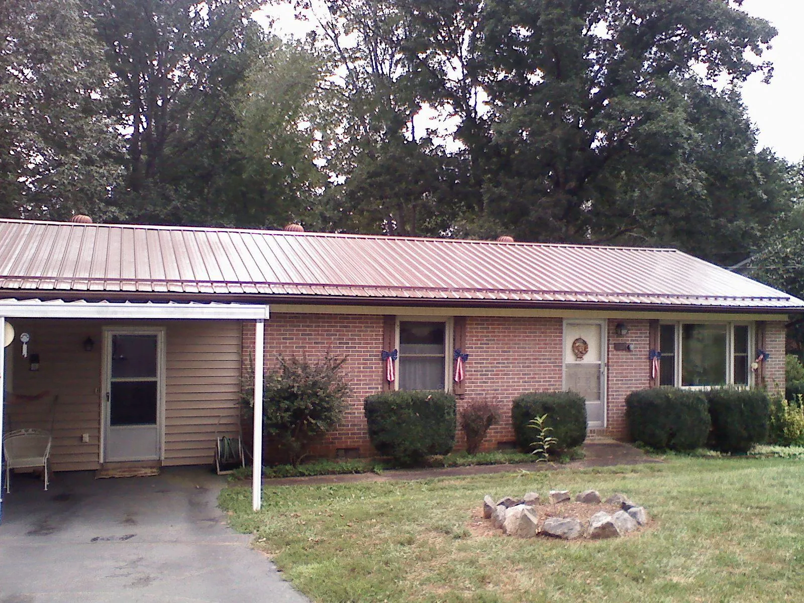 Bronze metal roof and carport on a brick ranch home — Roof Repair work by our crew in Anahuac